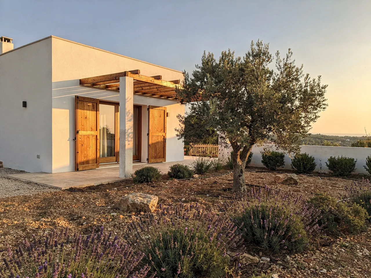 Vivienda unifamiliar terminada, con porche de madera y jardín de olivo y lavanda