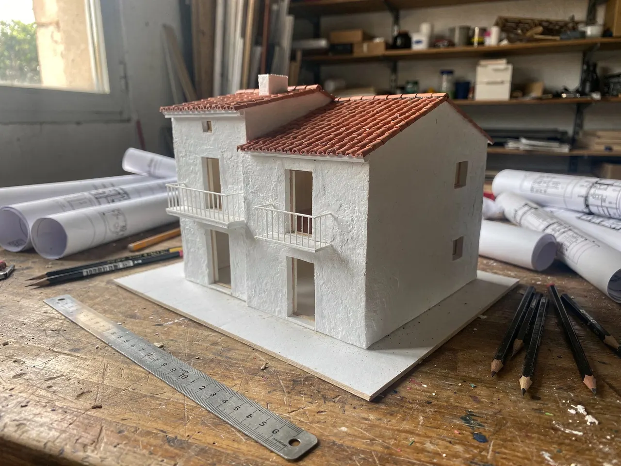 Maqueta de una vivienda sobre los planos, con regla y lápices
