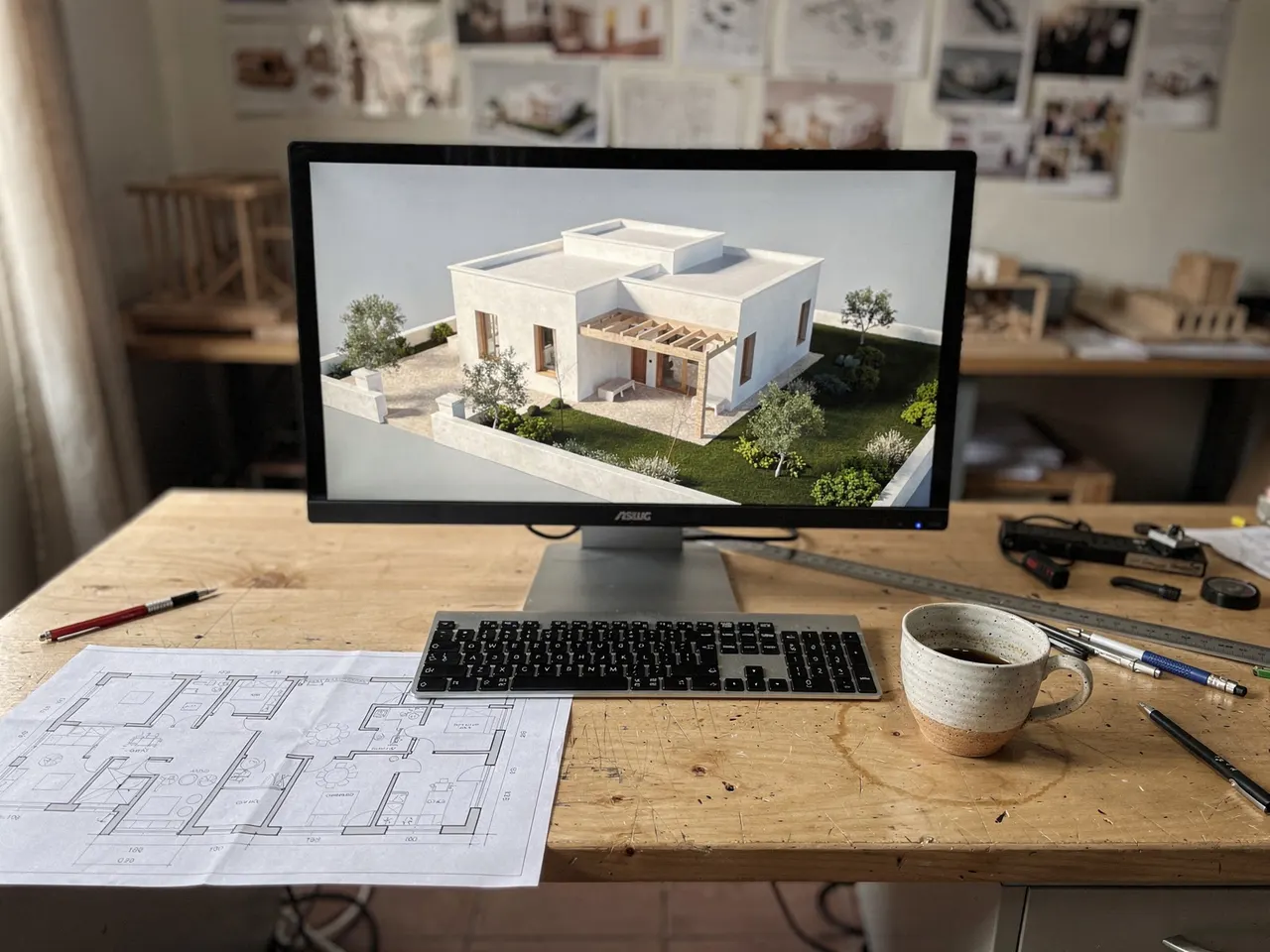 Modelo 3D de una vivienda en la pantalla, junto a su plano en papel